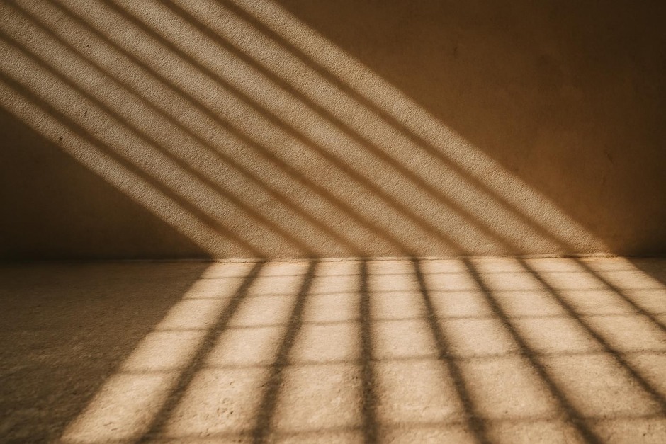 Sunlight casting patterned shadows across a textured floor and wall